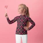 Kids pink abstract pattern rash guard with UPF 50+ protection, fitted design, and four-way stretch for active play.