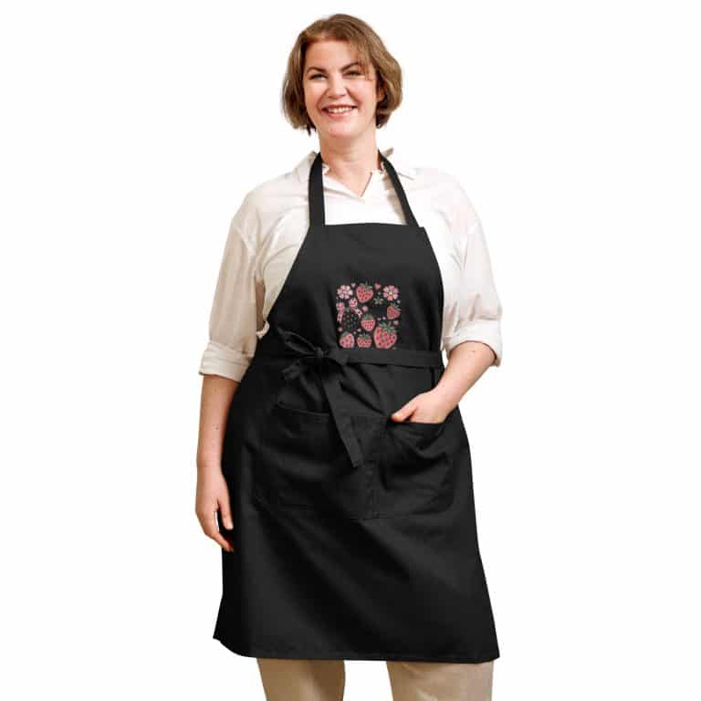 Organic cotton apron with vibrant strawberry design, adjustable straps, and large front pocket, 100% organic cotton.