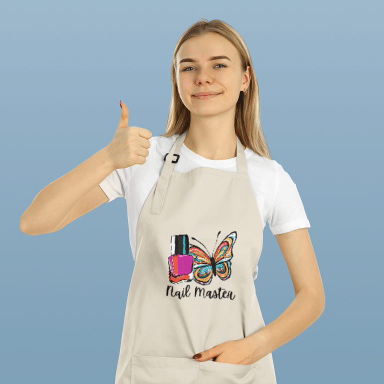 Organic cotton kitchen apron with large two-compartment front pocket, adjustable neck and waist straps, durable 240 gsm fabric, ethically sourced from Bangladesh.