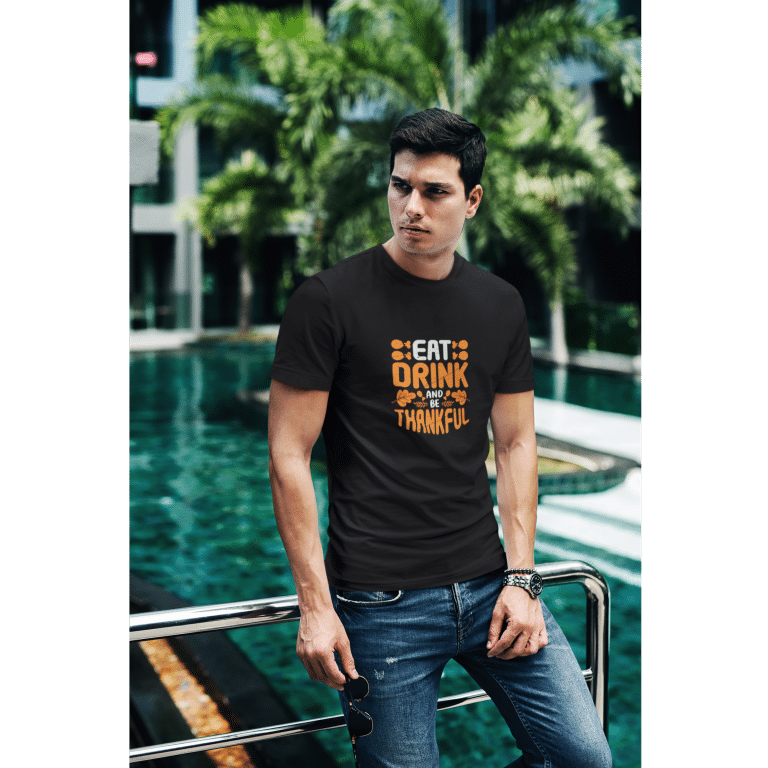 Cotton Heritage men's boxy tee featuring 'Eat Drink And Be Thankful' text, oversized relaxed fit, drop shoulder sleeves.