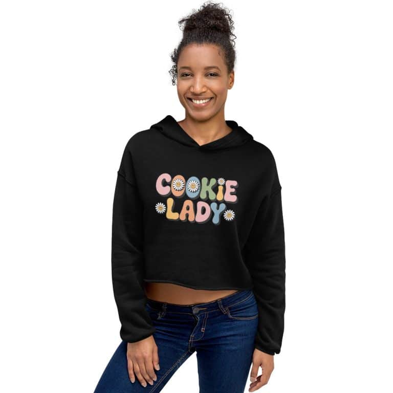 Crop Hoodie Cookie Lady by Bella+Canvas: pastel lettering, daisy details, raw hem, dropped shoulder, cozy cotton-poly fleece.